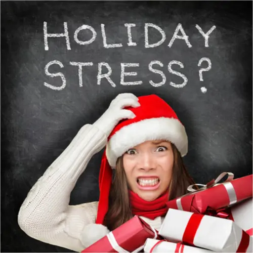A person wearing a Santa hat looks stressed, holding gifts with a chalkboard reading "Holiday Stress?"