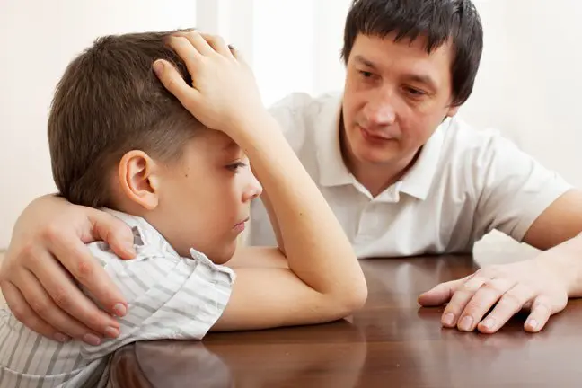 An adult appears to comfort a concerned child, emphasizing care and support.