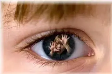 An eye reflecting an image of a child with hands raised, possibly indicating fear or surprise.