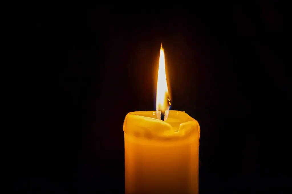 Lit candle with black background.