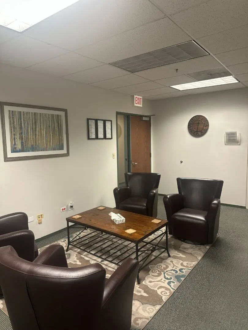 A waiting room with chairs, a table, and a decorative rug suggestive of a therapy office in Chicago.