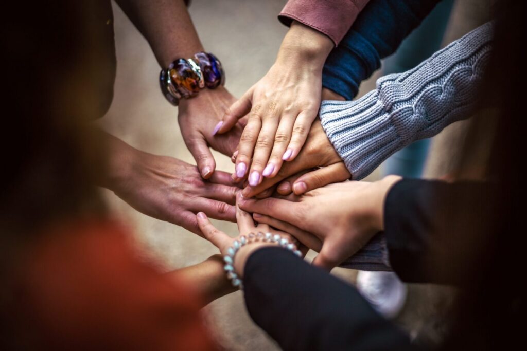 Multiple hands stacked together in unity
