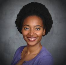 Smiling woman in purple sweater portrait.