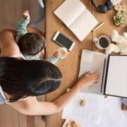 Parent multitasking with laptop and baby.