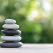 Stacked pebbles with blurred nature background.